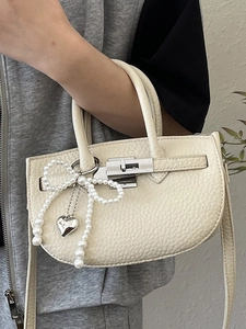 Elegant cream lychee pattern bucket bag with pearl bow and silver heart pendant detail