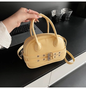 Détail du sac Boston jaune pâle avec boucles argentées et deux poignées supérieures
