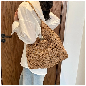 Détail du sac fourre-tout en paille café évidé avec bandoulière en cuir et anneau