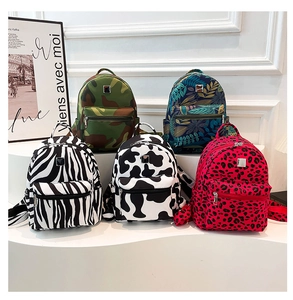 Selection of trendy backpacks in zebra, cow, camouflage, and floral prints on a display