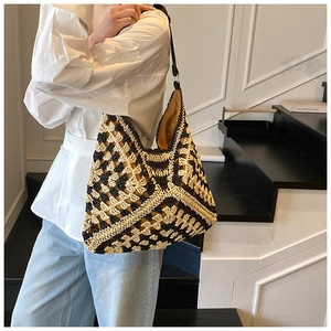Détail de la texture tissée et du motif bicolore sur ce grand sac cabas d'été en paille