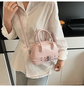 Détail du mini sac Boston rose clair porté en bandoulière avec sangle ajustable