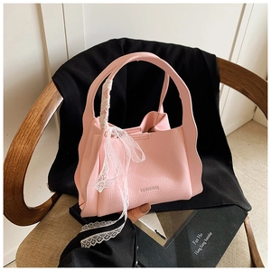 Pink lychee grain leather bucket bag featuring wavy edges and elegant white lace strap