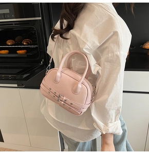 Détail du sac Boston rose pâle style Y2K avec sangles à boucles et œillets argentés