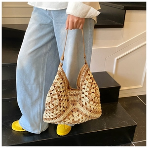 Détail du sac fourre-tout en paille évidée avec fines bandoulières en cuir marron d'été