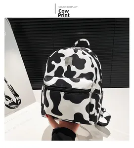Detail shot of a stylish mini backpack featuring a trendy black and white cow print pattern
