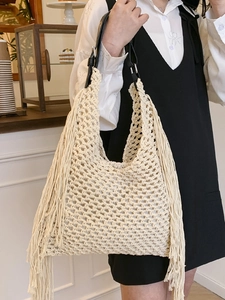 Minimalist woven tassel tote bag with adjustable black leather strap for beach vacation