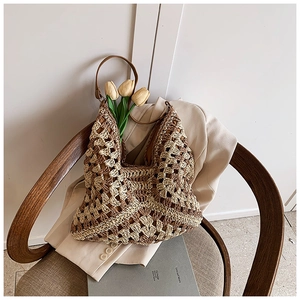 Vue détaillée du sac cabas en paille bicolore avec motif de tricot ajouré