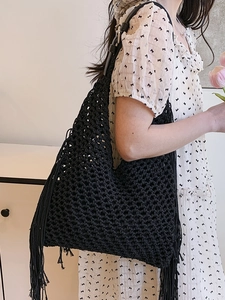 Handcrafted black hollow woven crochet tote bag with fringe tassels and slim leather straps