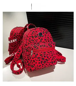Detail view of mini red leopard print backpack with silver zippers and front pocket