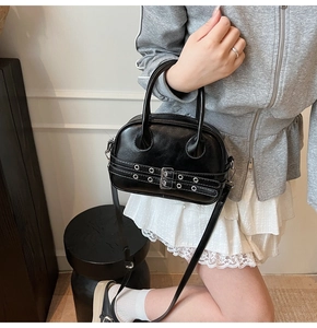 Gros plan détaillé d'un sac bowling punk en similicuir noir avec des œillets métalliques