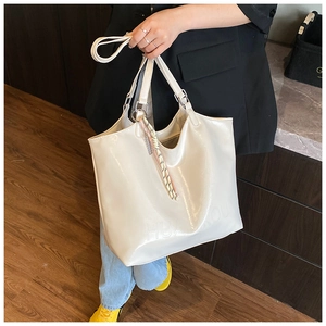Detail of white oil wax leather tote bag featuring HUA JIKOU brand logo embossing