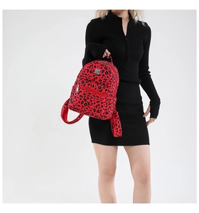 Mini backpack in vibrant red leopard print held by model against white background