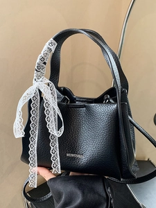 Black lychee leather bucket bag with white lace bow and elegant handle for women
