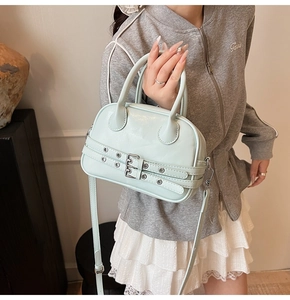 Détail du mini sac Boston vert menthe avec boucles argentées et finition en cuir lisse