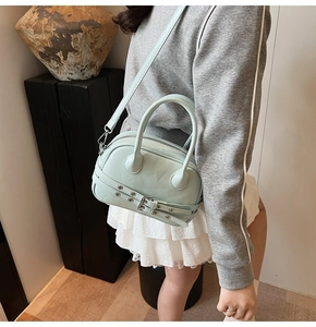 Détail du sac Boston vert menthe avec lanières à boucles et œillets métalliques