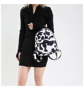 Detail view of stylish cow print backpack showing classic black and white animal pattern
