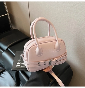 Détail du sac Boston rose clair en cuir PU brillant avec ceintures à œillets décoratives