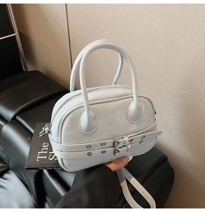 Détail du sac Boston en cuir verni brillant avec boucles métalliques et bandoulière