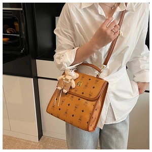 Détail d'un sac à main vintage en cuir marron avec imprimé lapin et peluche d'ours