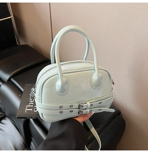 Détail du sac Boston vert menthe en cuir brillant avec boucles métalliques et finitions argent