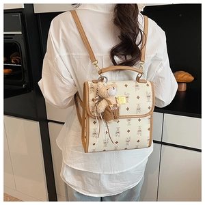 Détail d'un sac à dos monogramme crème avec motifs de lapins et pendentif ours