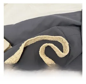 Close-up of the beige hand-woven crochet handle showing intricate hollow texture and patterns