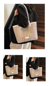Detail of colorful woven straw tote bag with white leather straps and vertical stripes
