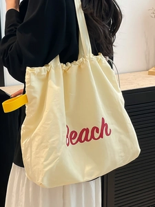 Minimalist beige canvas tote bag with red Beach print and yellow straps for beach use