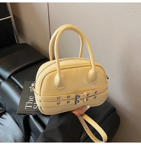 Détail du sac Boston beige avec sangles décoratives et œillets métalliques argentés