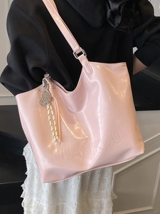 Pink oily wax leather tote bag with HUANKOU logo and tennis racket charm worn by model