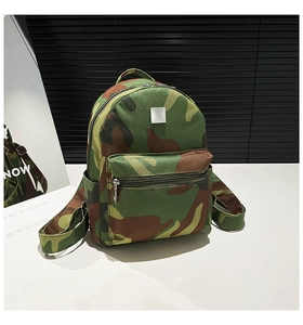 Detail showing the camouflage pattern canvas texture and metal plate on the backpack