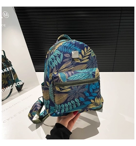 Detail of mini backpack with tropical leaf print and functional front zipper pocket