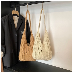 Detailed view of hollow knit patterns on caramel brown and cream tote bags