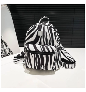 Detailed close-up of zebra print backpack showing the durable fabric and silver zippers