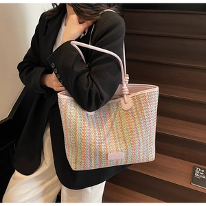 Detail of colorful woven tote bag with pink leather handles and YUEMARQI logo