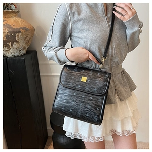 Gros plan sur un sac bandoulière en cuir grainé noir avec des motifs de dessins animés
