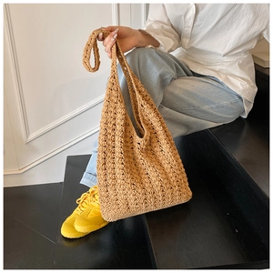 Detail shot of the hollow woven tote bag showing its intricate texture and beige pattern
