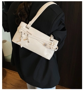 Détail d'un sac sous les bras en cuir PU blanc avec pendentif étoile et œillets métalliques