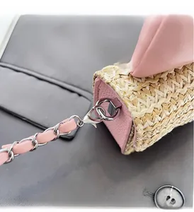 Detail of pink lychee leather and beige woven straw with silver chain strap