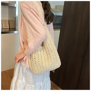 Close-up of beige crochet tote bag with hollow wave texture and broad woven strap