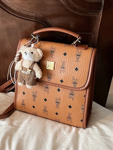 Sac à main vintage en cuir marron avec motif losanges et charmant pendentif ours