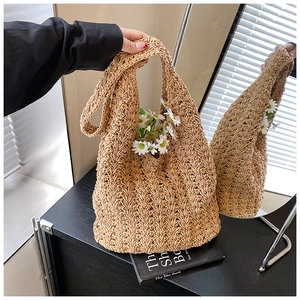 Detail of hand-woven hollow knit tote bag in beige with texture and daisy accents