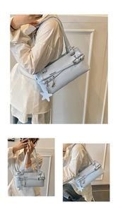 Detail of light blue faux leather handbag featuring metal star pendant and buckle strap