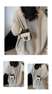 Detail of mini straw crossbody bag featuring black lacquer bow and silver flower lock