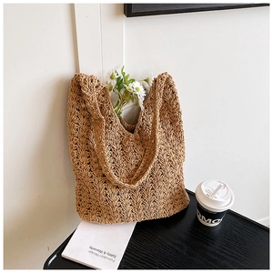 Detailed view of brown woven straw tote bag featuring intricate V-shaped crochet patterns
