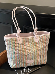Colorful striped woven straw tote bag with pink handles for summer beach travel and commuting