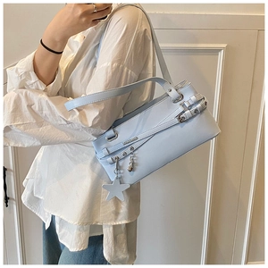 Gros plan du sac à bandoulière bleu clair en cuir mat avec charms en étoile