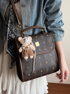 Sac à main vintage marron avec monogramme et charm ours porté par un mannequin