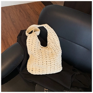 Detail of minimalist cream hollow crochet tote bag with wave pattern on dark background